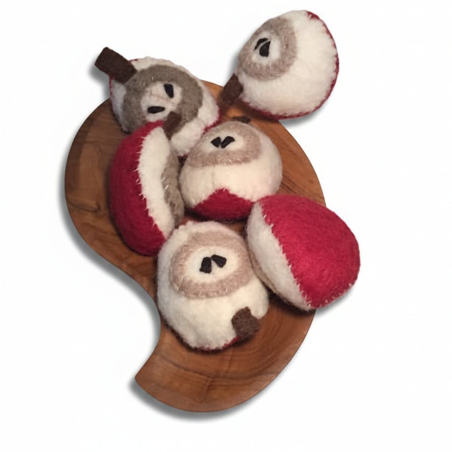 Six slices of felted apple on a wooden platter on a white background