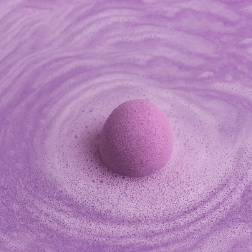 Purple bath bomb fizzing in a swirling purple bath.