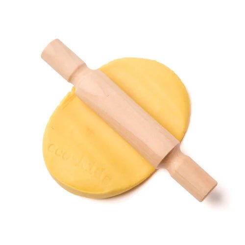 Wooden rolling pin on a ball of yellow eco-dough on a white background
