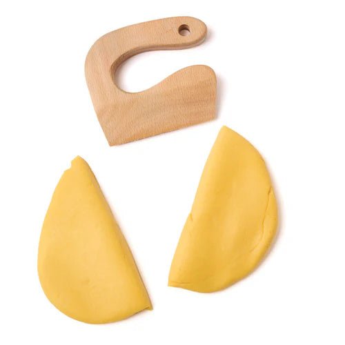 Wooden knife with yellow eco-dough that has been cut into two pieces on a white background