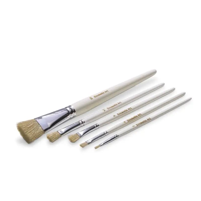Set of five encaustic art brushes with plain wooden handles laid flat