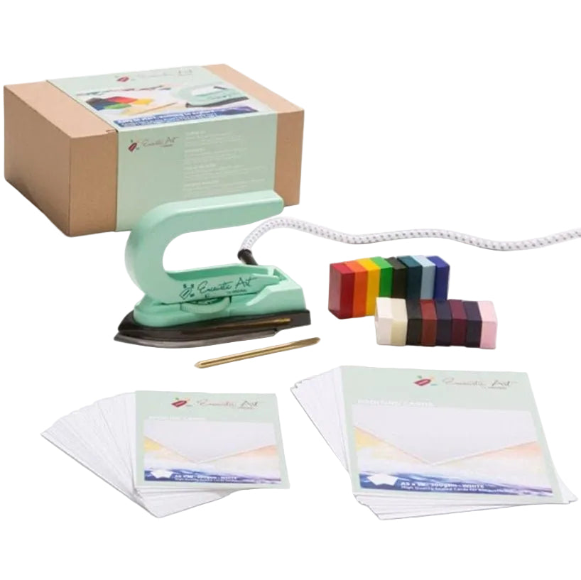 Green Encaustic Art iron, colorful blocks, and stationery items on a white background