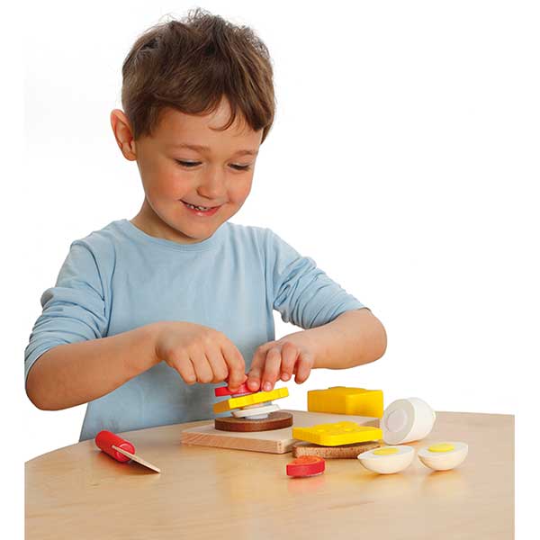 Child making a sandwich with wooden sandwich set