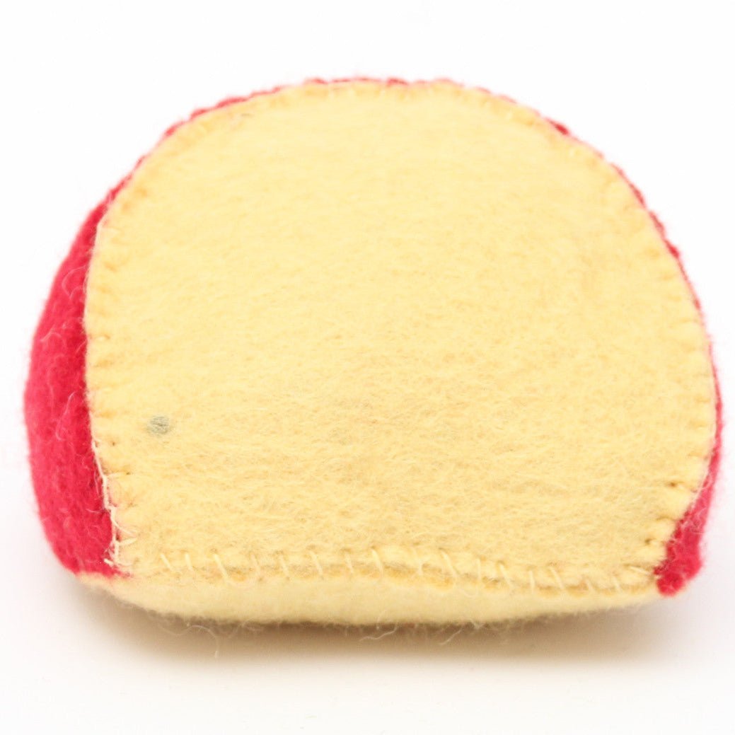 Felted wedge of gouda cheese on its side on a white background