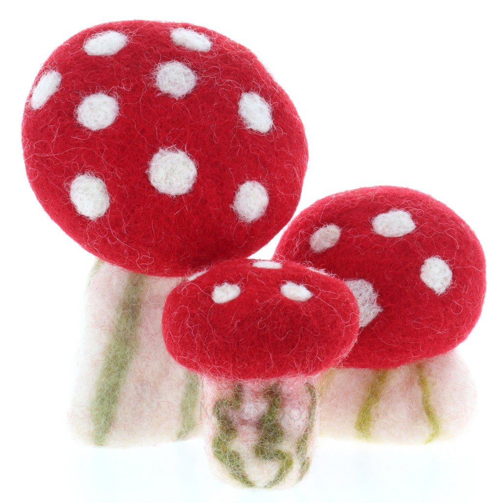 3 red and white felted mushrooms of different sizes on a white background
