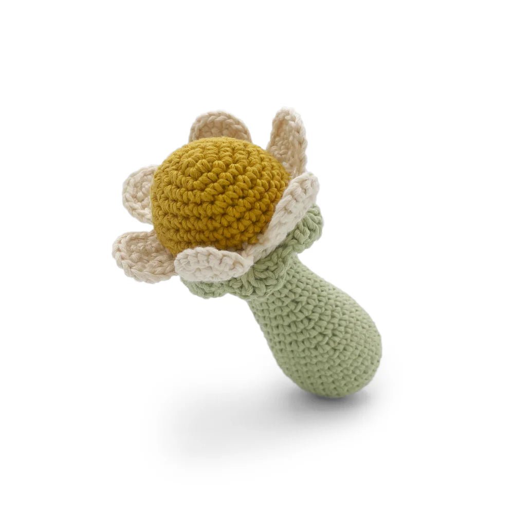 Crocheted toy resembling a flower with a green stem on a white background