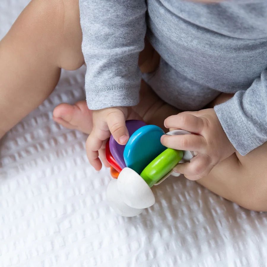 Baby holding a small colorful wooden toy car