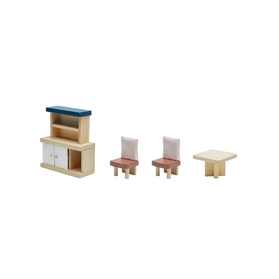 Wooden doll furniture lined up in a row, including a shelf and cabinet, 2 chairs, and a table
