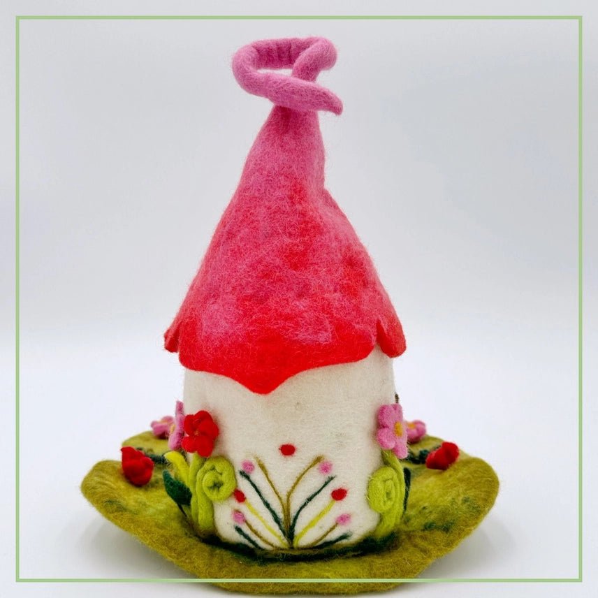 Back side of felted fairy house with red roof on a white background