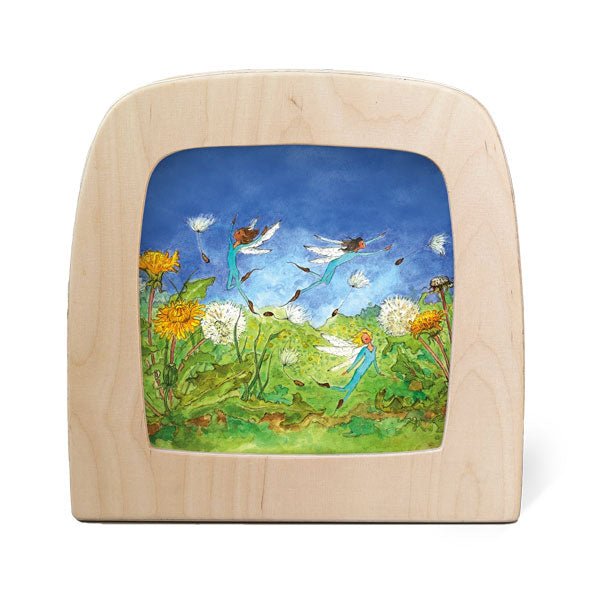 Wooden frame with silhouette of fairies flying around a field of dandelions