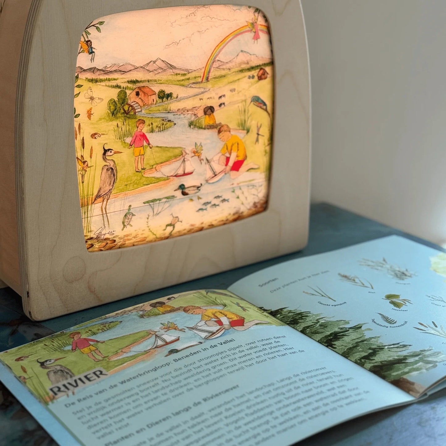 Wooden frame with silhouette of children playing in an estuary with lots of different types of birds.