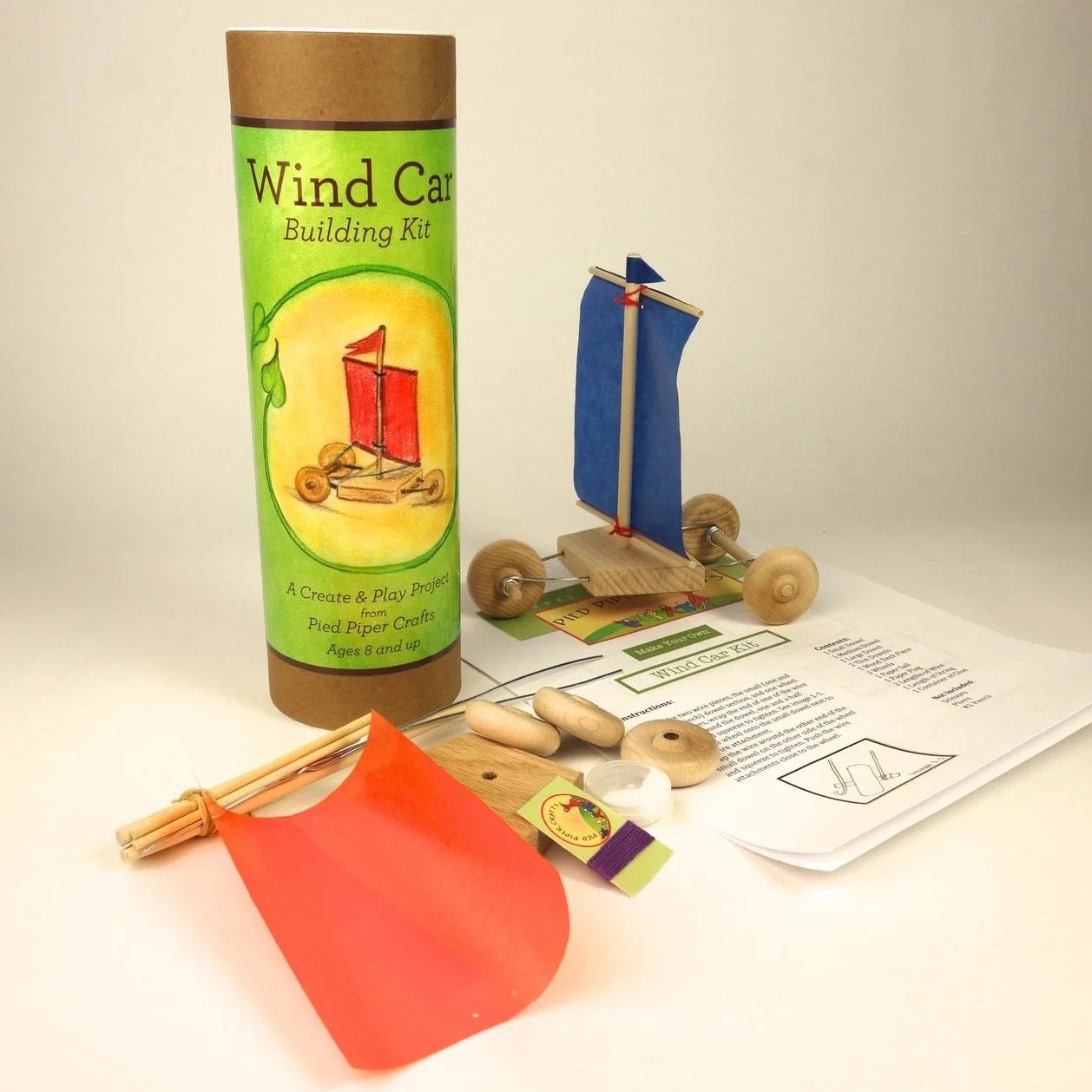 Wind car building kit with all of the materials laid out on a light beige background