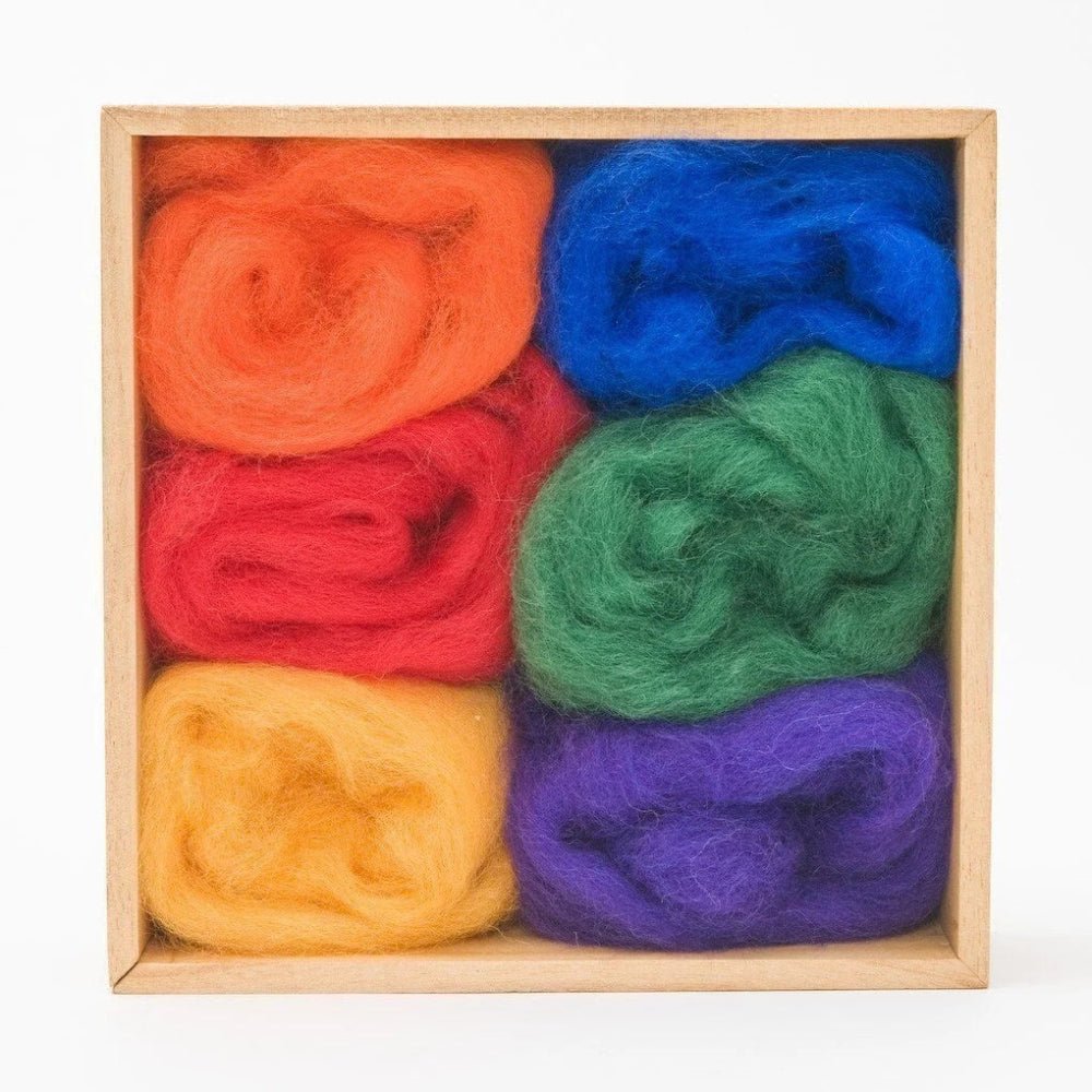 6 balls of wool in rainbow colors in a wooden storage box on a white background