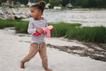A child walking on the beach with a cotton doll