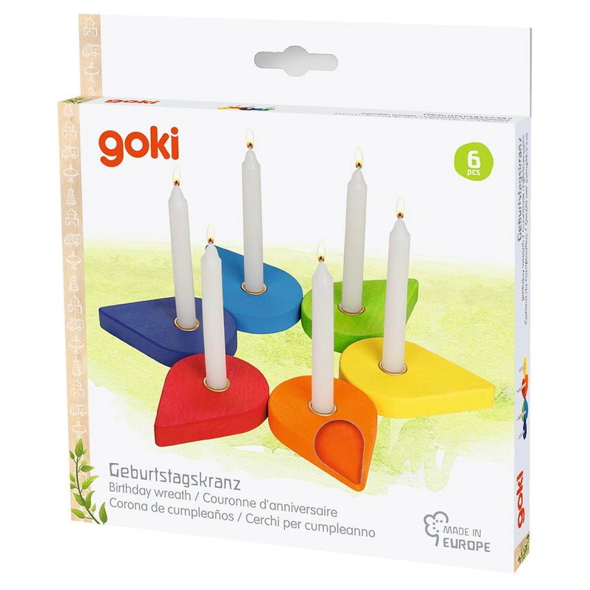 Goki 6-piece wooden birthday wreath candle holder set in its original retail packaging, featuring six colorful wooden shapes in blue, red, orange, yellow, green, and purple, each holding a white taper candle.