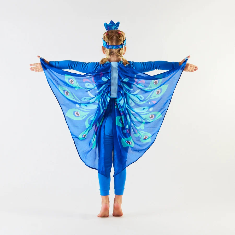 Child with back towards camera, wearing an all blue outfit with blue silk peacock wings on a white background