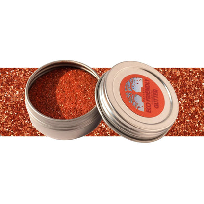 Tin of loose bronze glitter on a white background with a stripe of bronze in the middle