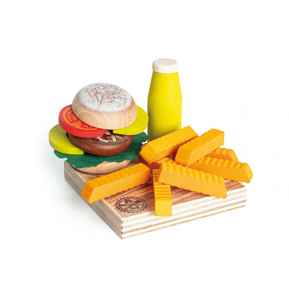 Wooden veggie burger, sauce bottle, and sweet potato fries on a serving board against a white background