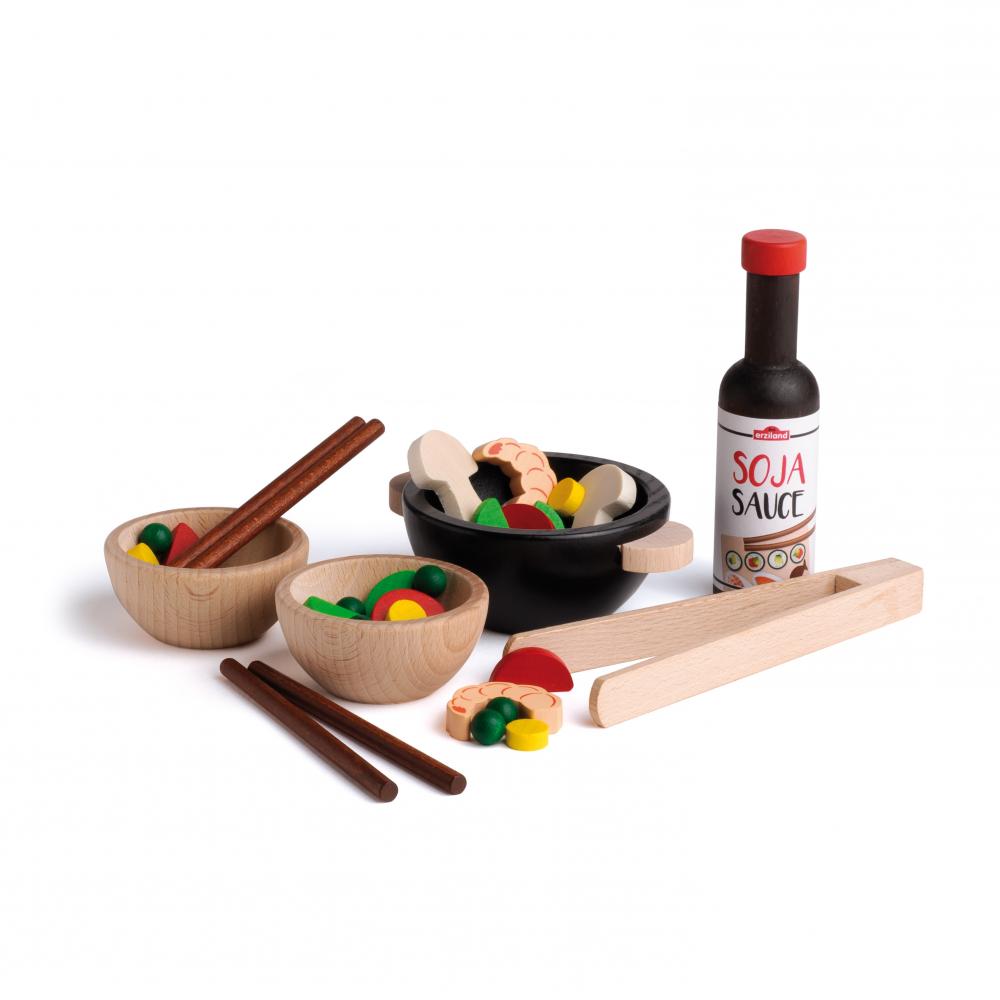 Assortment of wooden bowls, chopsticks, shrimp, veggies, and soy sauce on a white background