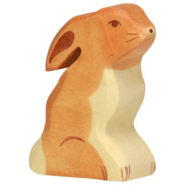 Wooden toy rabbit sitting against a white background