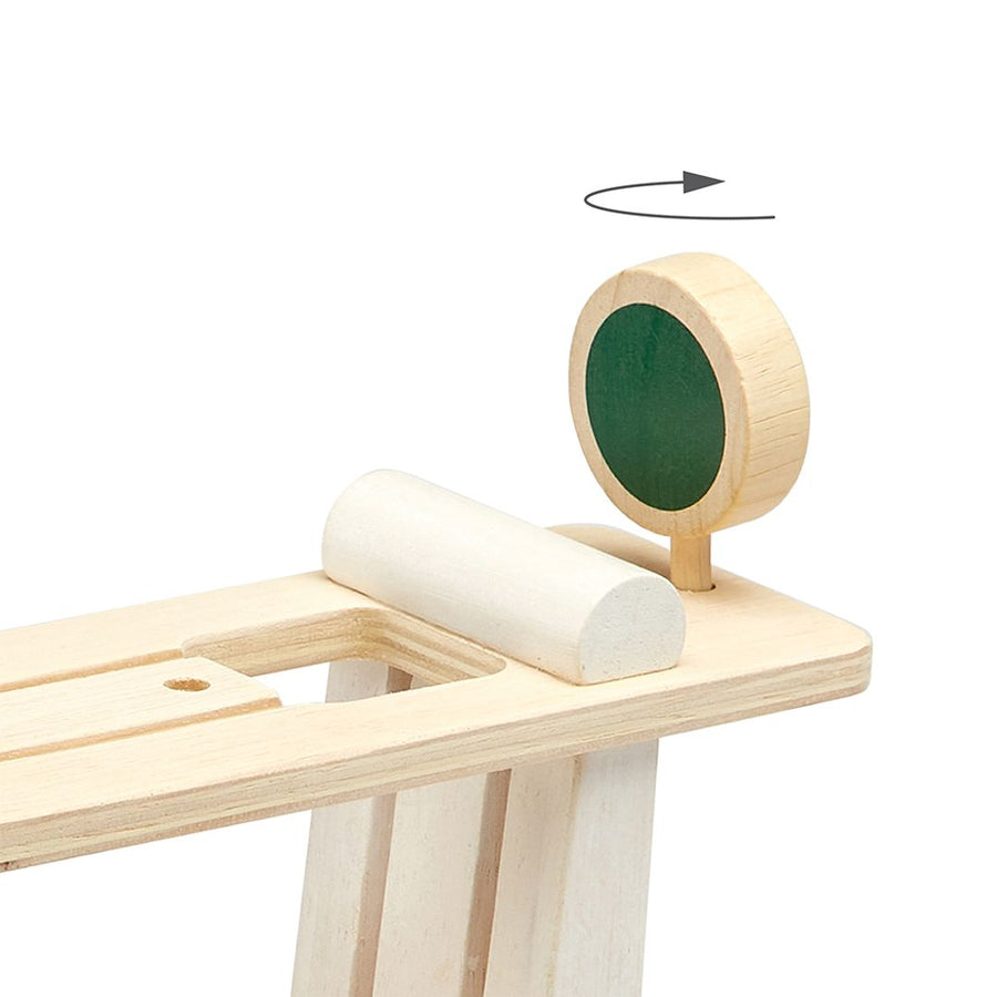 Top of wooden race track ramp with a green sign