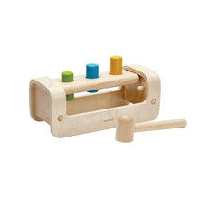 Wooden bench with pegs and a mallet on a white background