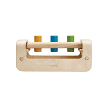 Wooden peg board with yellow, blue, and green pegs on a white background