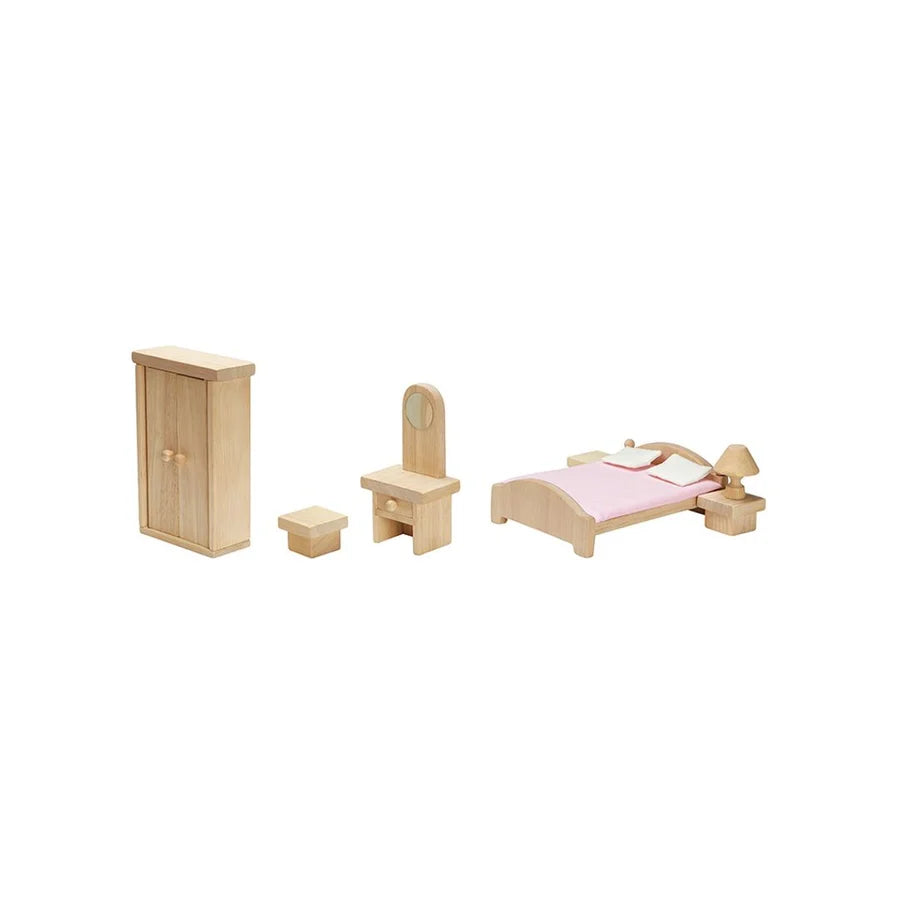 Dollhouse bedroom furniture lined in a row including closet, stool, vanity, bed with side tables and lamp
