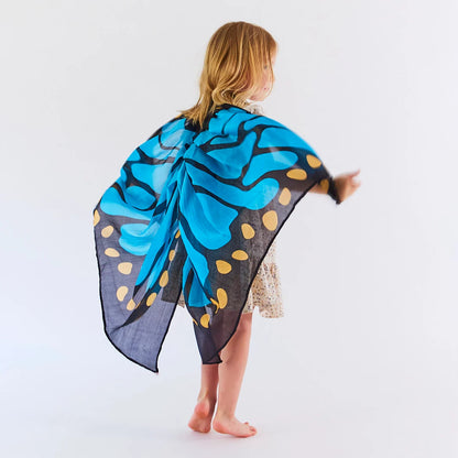 Child wearing blue silk butterfly wings on a white background