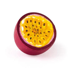 Purple wooden passionfruit half with yellow inside and brown seeds on a white background