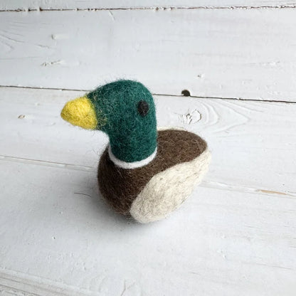 Handcrafted felted duck toy on a white wooden surface