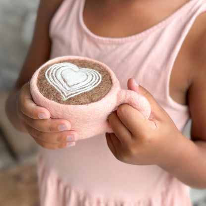 Child holding pink felt coffee cup with a heart one top