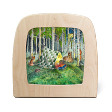 Silhouette of children reading in a tent in the forest surrounded by woodland creatures