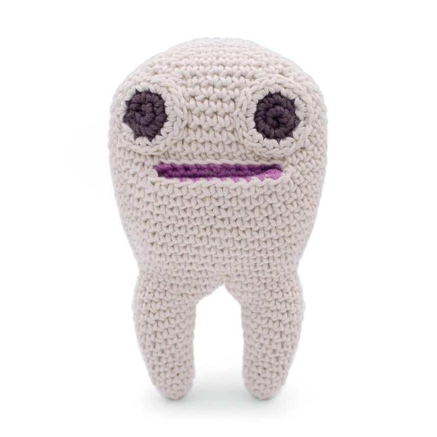 Crocheted tooth with two large eyes and a mouth on a white background