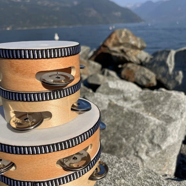 Wooden tambourine on a rocky surface with a mountainous landscape in the background