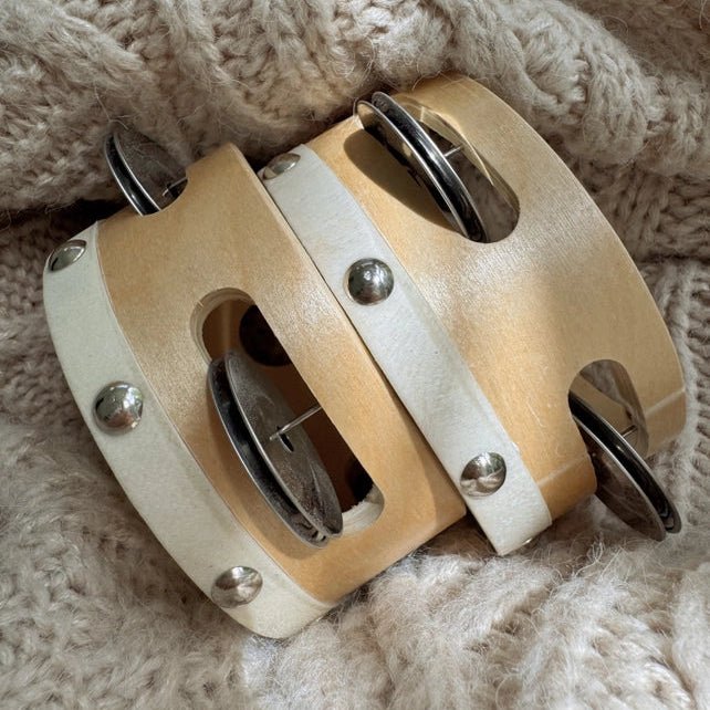 Pair of single row tambourines on a fabric background