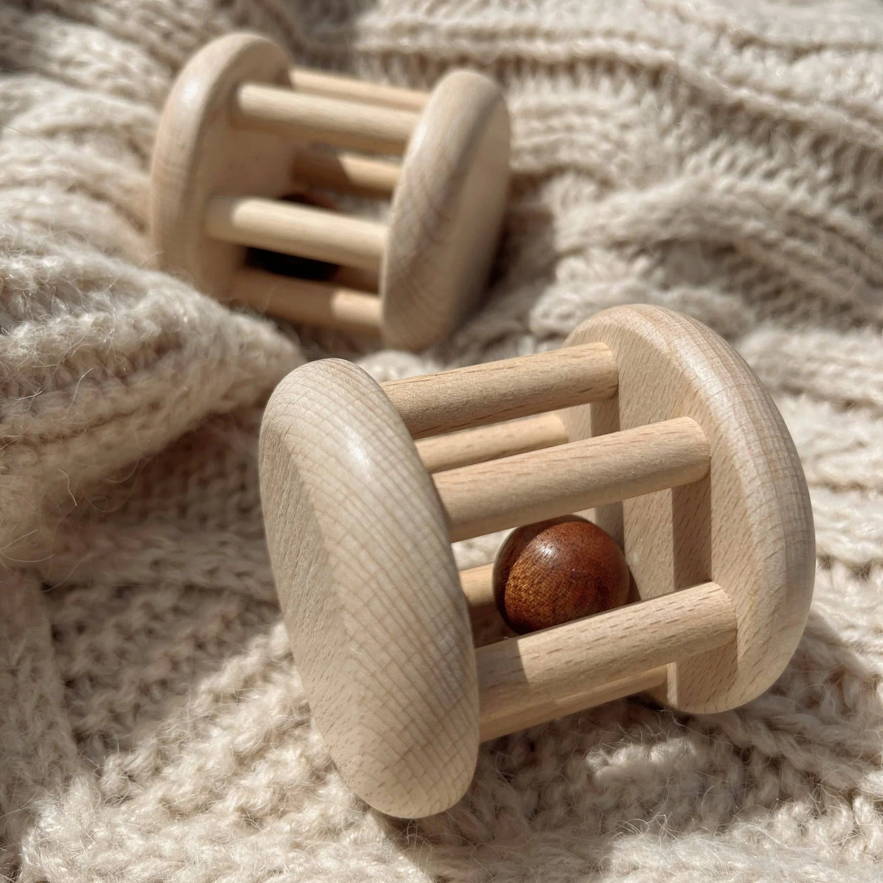 Wooden baby rattles on a soft fabric background