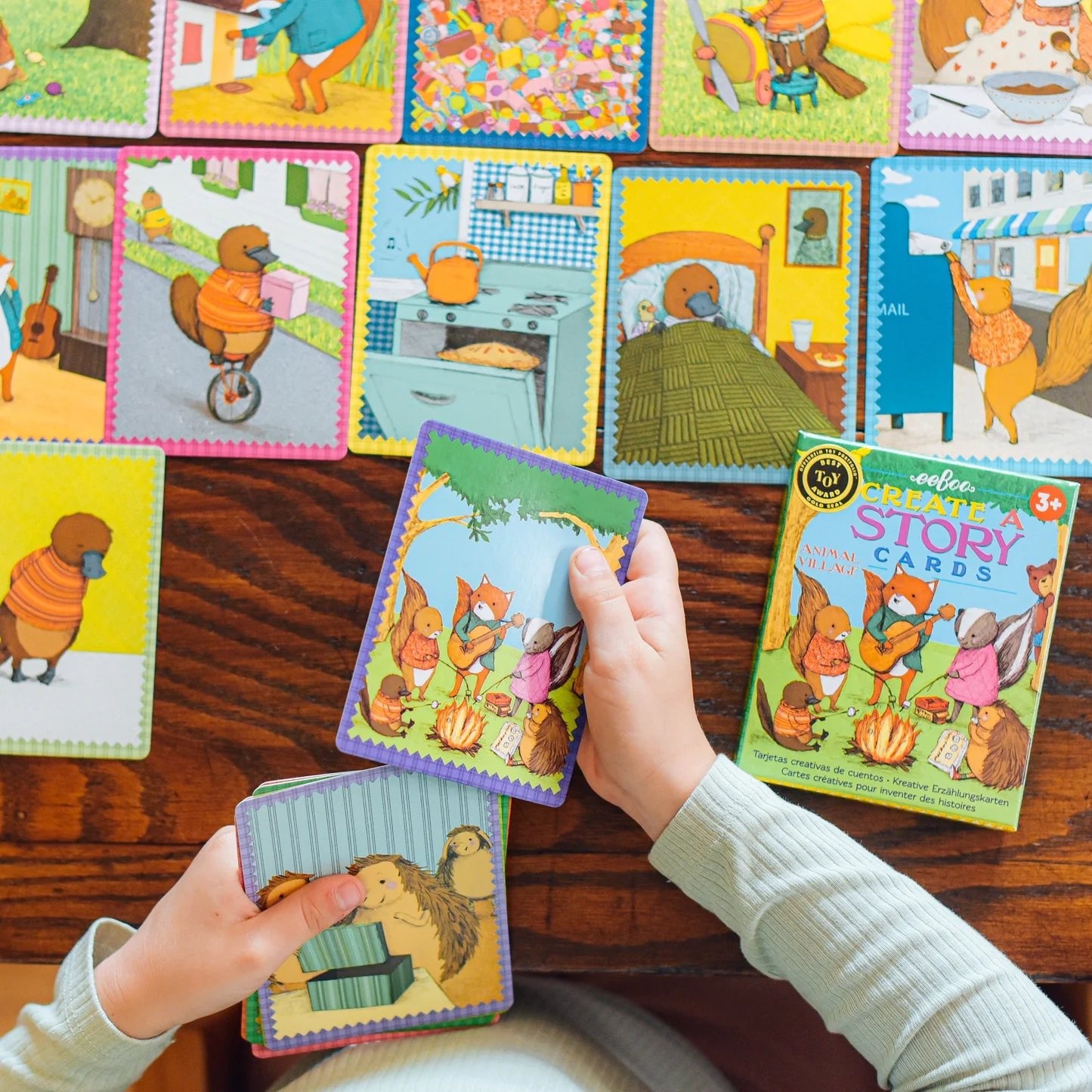 Child playing with colorful story cards on a wooden surface