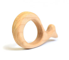 A light natural wood baby teether shaped like a whale, shown on a clean white background with a soft shadow.