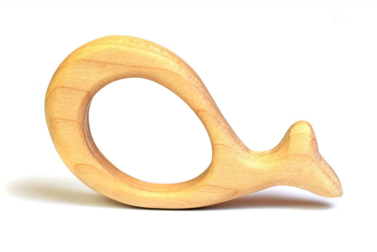 A light natural wood baby teething ring with a smooth, rounded finish, photographed on a clean white background with a soft shadow.