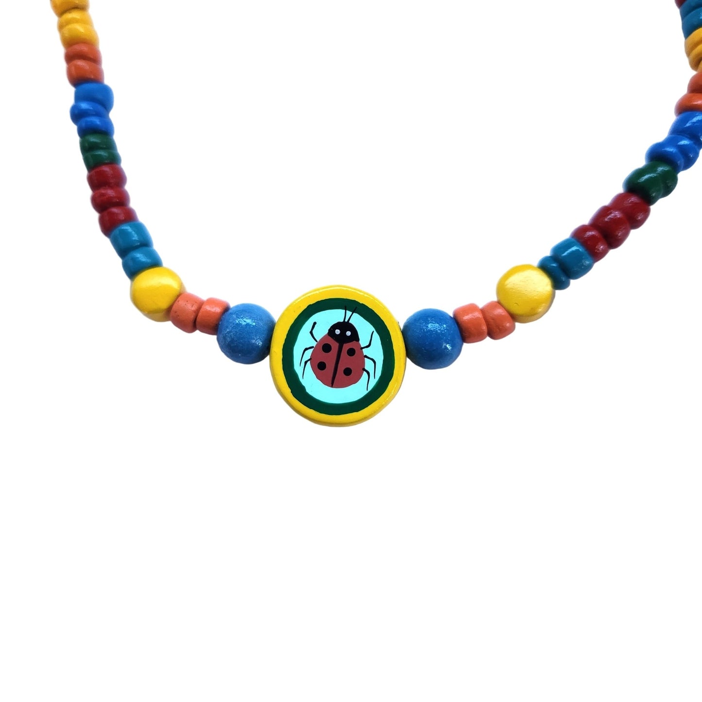 Close up of a colorful wooden beaded necklace with a ladybug pendant on a white background