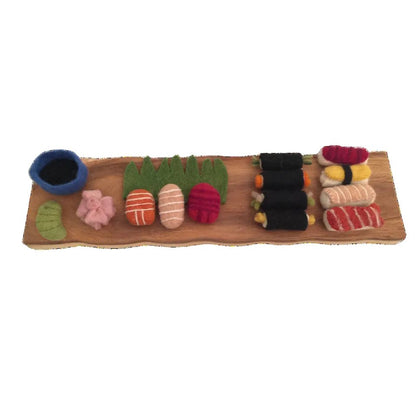 Variety of felted sushi on a wooden platter on a white background