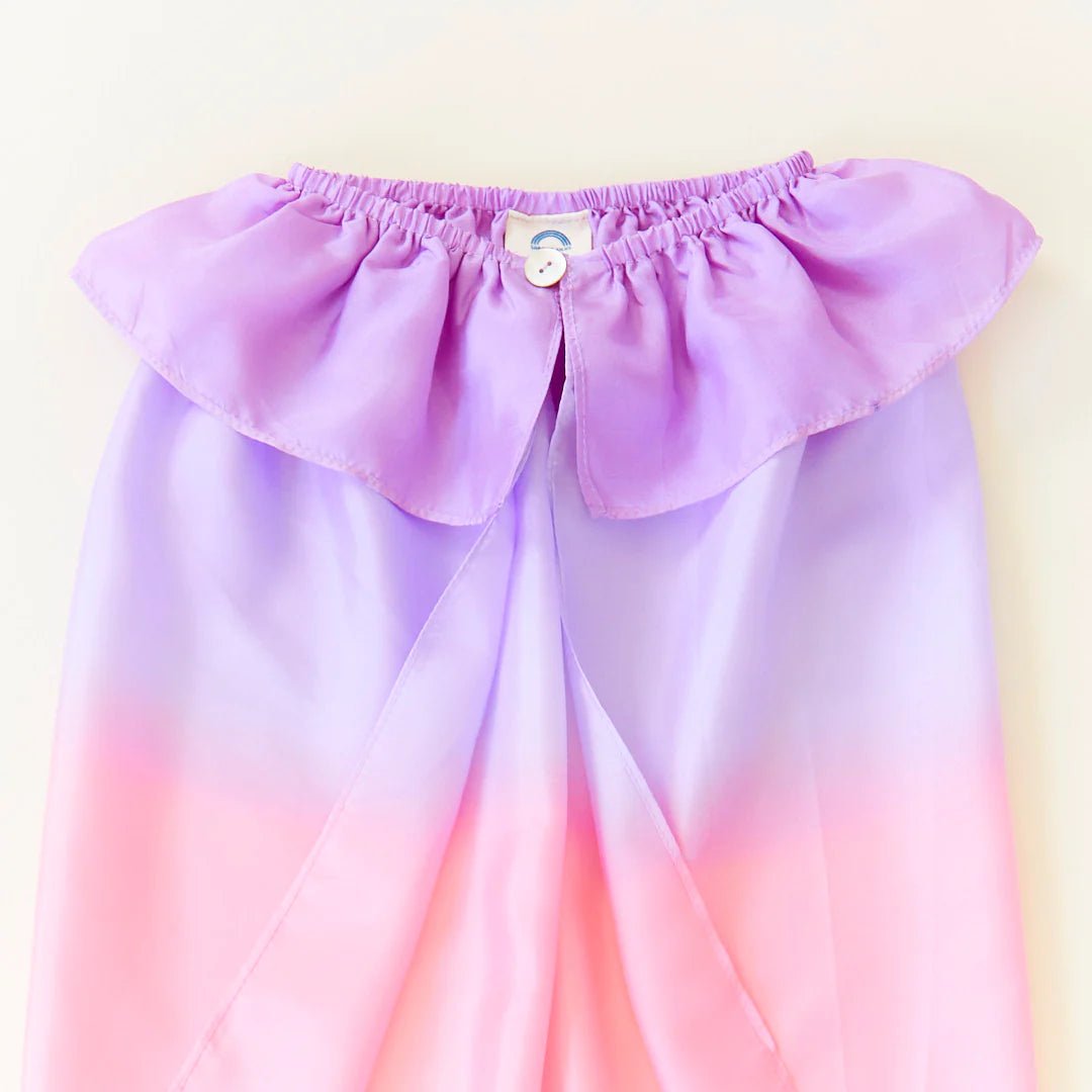 Gradient purple to pink silk cape with ruffled top and button closure on a white background