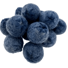 Pile of felted blueberries on a white background