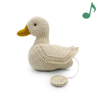 Crocheted duck with pull string and a musical note on a white background
