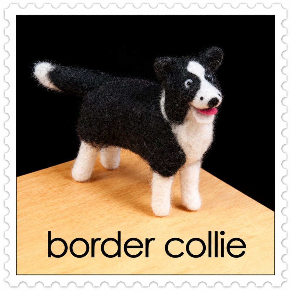 Felted border collie on a wooden surface against a black background
