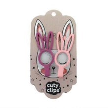 Two bunny-shaped hair clips in pink and purple on a 'cuty clips' branded card with a plain background.