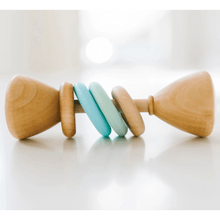 Wooden baby rattle with colorful blue rings on a white surface