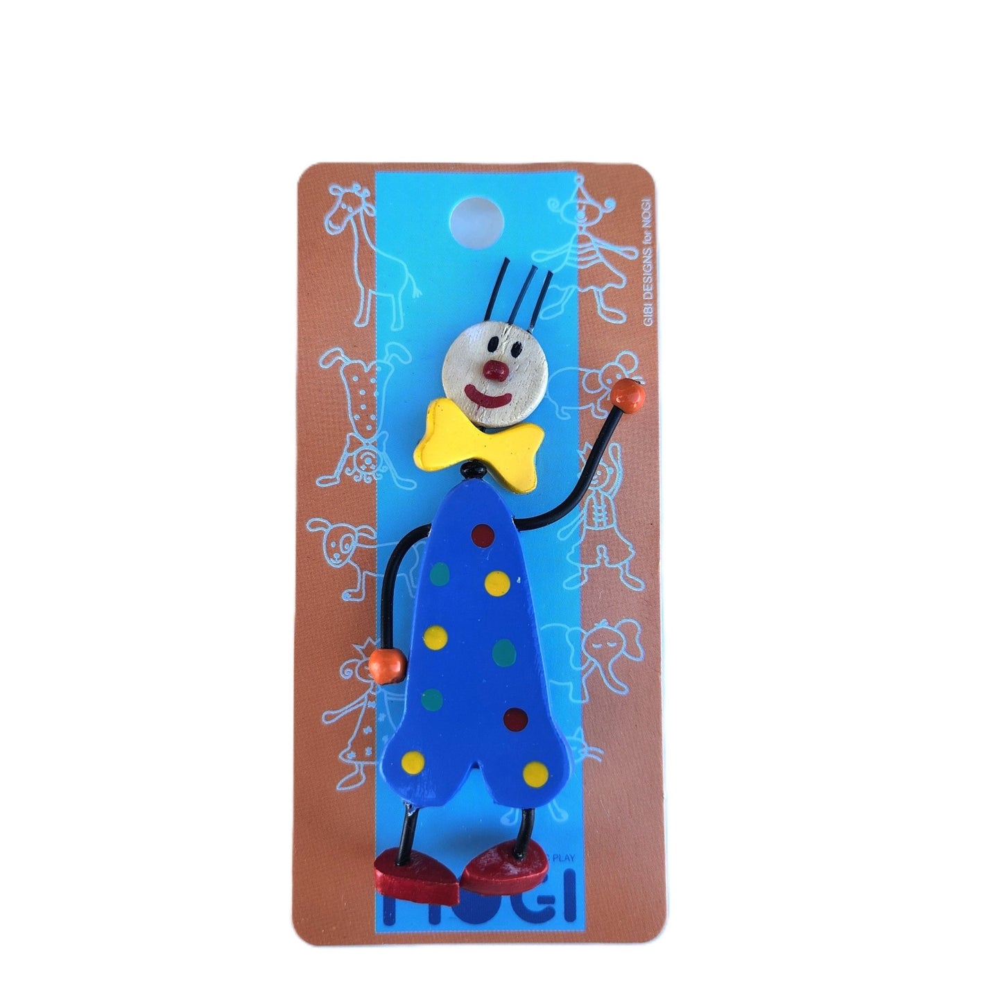 Wooden pin of a clown wearing a blue polka dot onesie on Nogi branded packaging