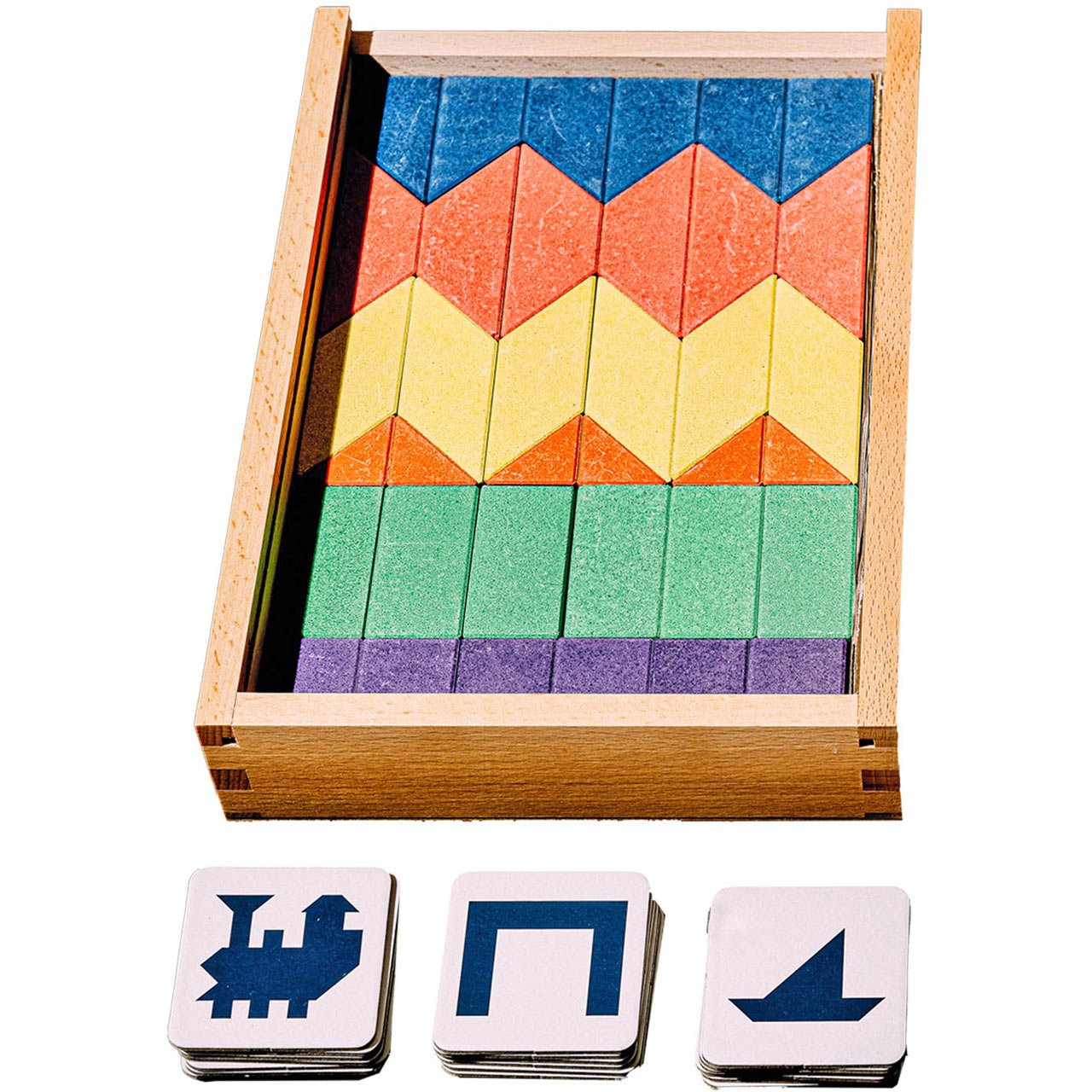 Colorful wooden blocks with geometric patterns in a wooden box, accompanied by three stacks of cardboard template cards
